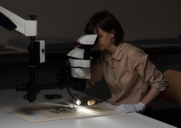 Die Restauratorin Dorothea Spitza bei der Untersuchung von technischen Merkmalen an Druckgraphiken, Zeichnungen und Malereien auf Papier unter dem Mikroskop.
 - © © Kunstmuseum Bern